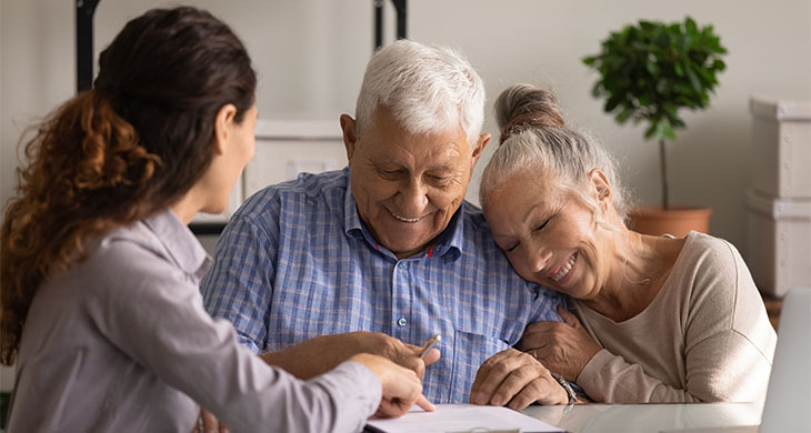 Pareja de ancianos felices firmando un documento