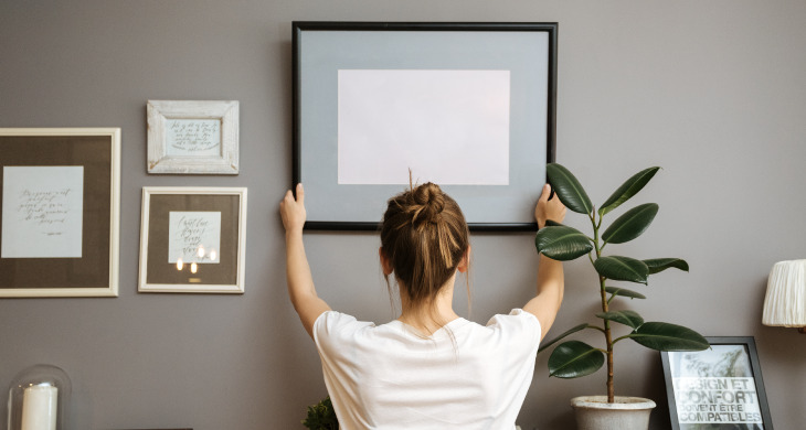 Mujer decorando las paredes de su hogar